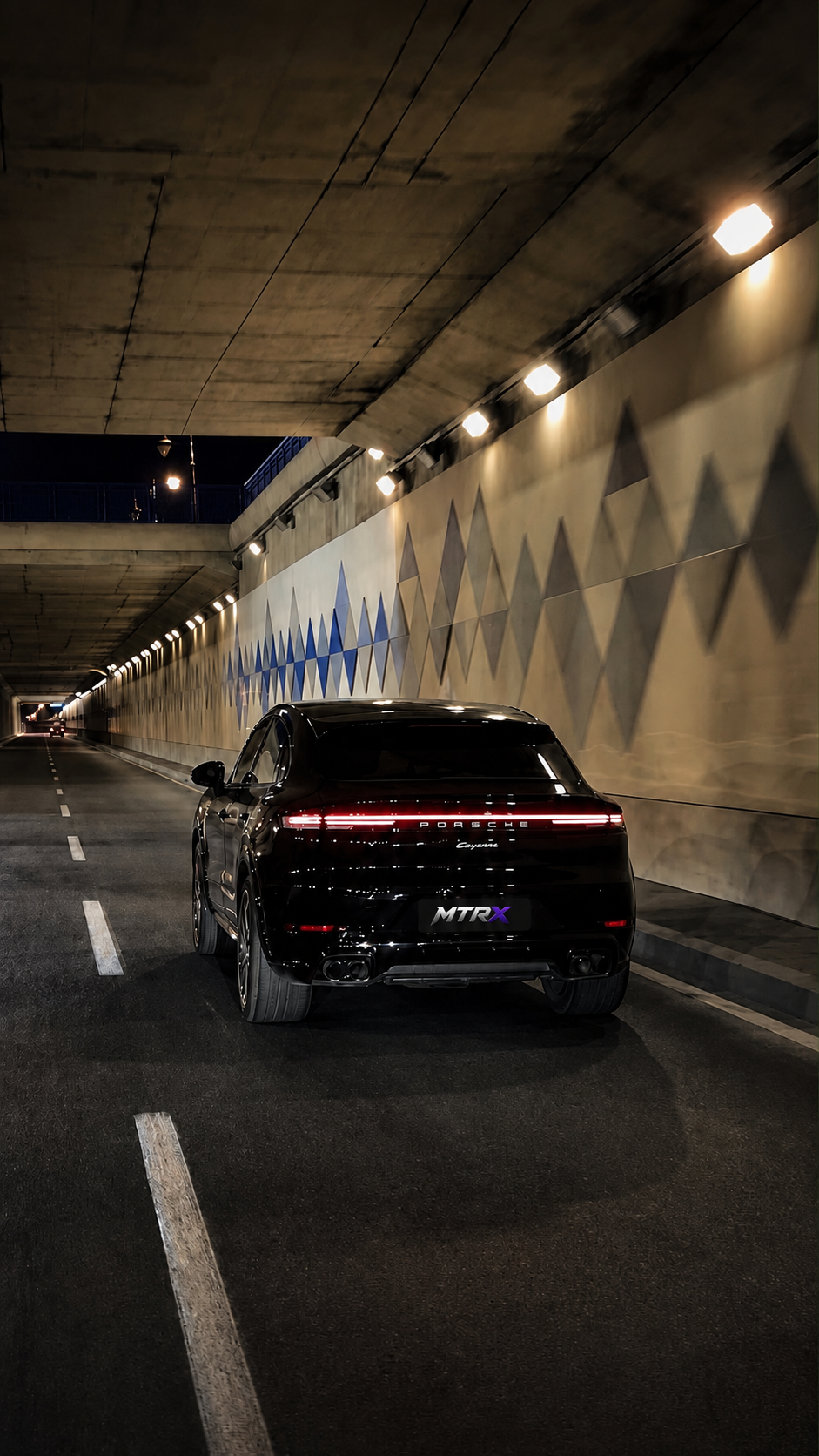 Black Porsche Cayenne driving through a premium urban tunnel